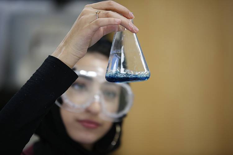 High school student holding a beaker in a science lab